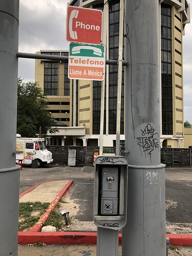 A neglected public telephone without the receiver. Even if the receiver were physically intact, a missing dial tone would render this phone a non-amenity.