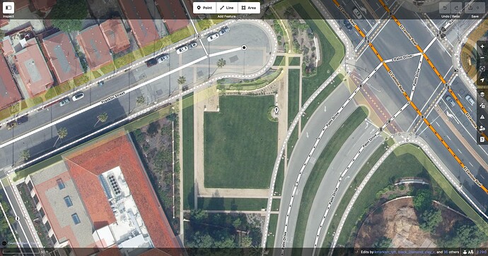 A pattern of beige brick pavers consisting of two concentric rectangles, laid into a grassy lawn and extending into the roadway of Franklin Street to the northwest but not into the roadway of Palm Drive to the southeast.