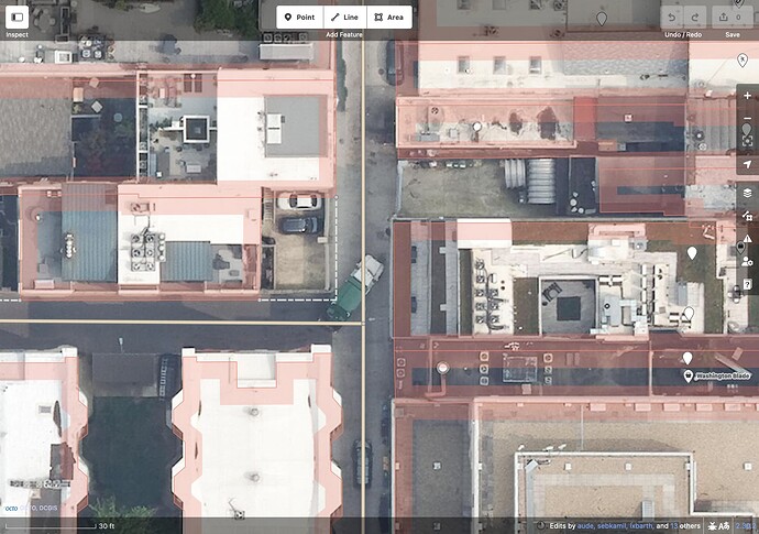 A garbage truck turns left from one alley to another at a T-intersection outside the Mapbox garage. Though surrounded by closely packed buildings, both alleys are wide enough to accommodate this truck, maybe even two abreast in a tight squeeze.