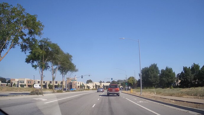 A left turn lane, two through lanes, and a bike lane that has a dashed lane divider indicating that motorists may use it to turn right. A road marking indicates that cyclists use the same lane to continue straight through.