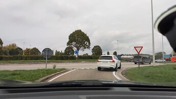A street-level view of shark’s-teeth road markings and a give-way sign at the entrance to a roundabout. (© 2022 miklav, CC BY-SA 4.0)