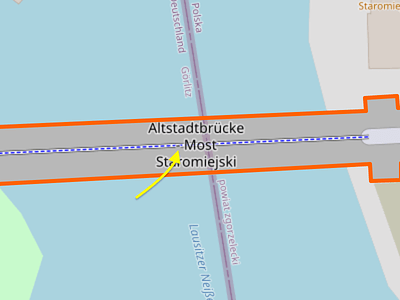 An arrow points to the hyphen in the label “Altstadtbrücke - Most Staromiejski”. The hyphen is barely discernible because it happens to be positioned as if it is one of the dashes in the cycleway running along the middle of the bridge. It somewhat resembles a bollard according to this style. The joke is that this bollard prevents either language from passing through, but neither language is prevented from accessing their respective ends of the bridge.