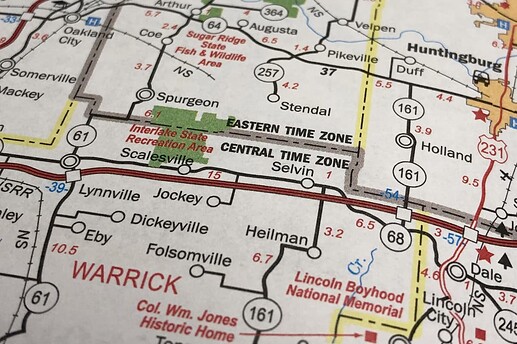 An excerpt of the official transportation and tourism map of Indiana shows the boundary between the Eastern and Central time zones as a dark gray halo surrounding a county line, supplanting the faint yellow halo normally given to county lines.