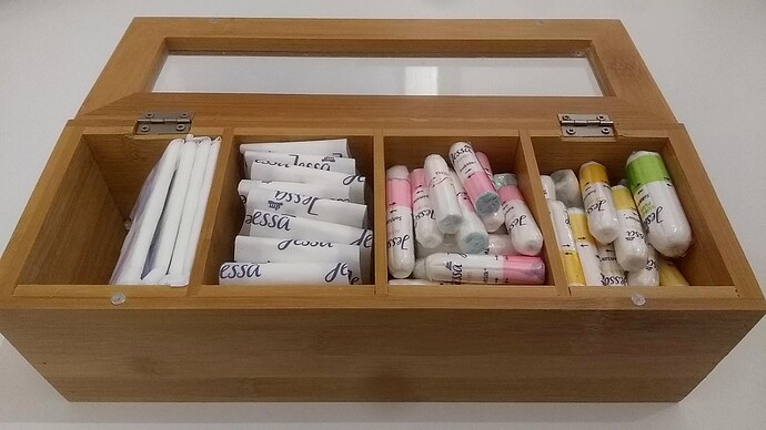 Picture showing a wooden box full of tampons and pads of different sizes