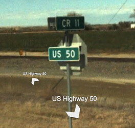 A street name sign for “CR11” mounted atop a stop sign, with another street name sign for “US50” mounted on the back of the stop sign.