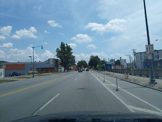 A regulatory sign has three arrows side by side representing three lanes. The center lane is labeled No Stopping No Parking 7–9 AM Monday to Friday, Tow Zone. The right lane has a pictogram of a bicycle and is labeled No Stopping Anytime, Tow Zone. The right lane has a solid divider while the left lane has a standard lane divider. (© 2019 realadamp, CC BY-SA 4.0.)