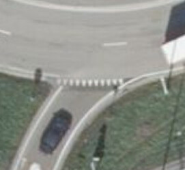 An aerial view of shark’s-teeth road markings at the entrance to a roundabout.