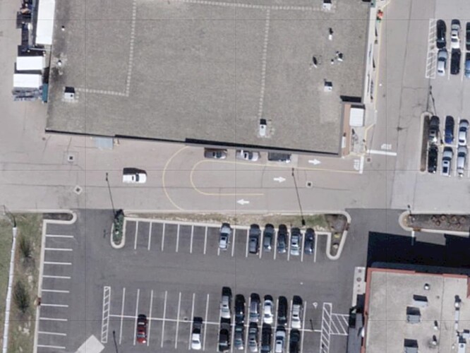 Three cars wait in a drive-through lane that curls around the adjacent parking lot circulation road, which is one-way, as another car approaches. (Ohio Statewide Imagery Program, public domain.)